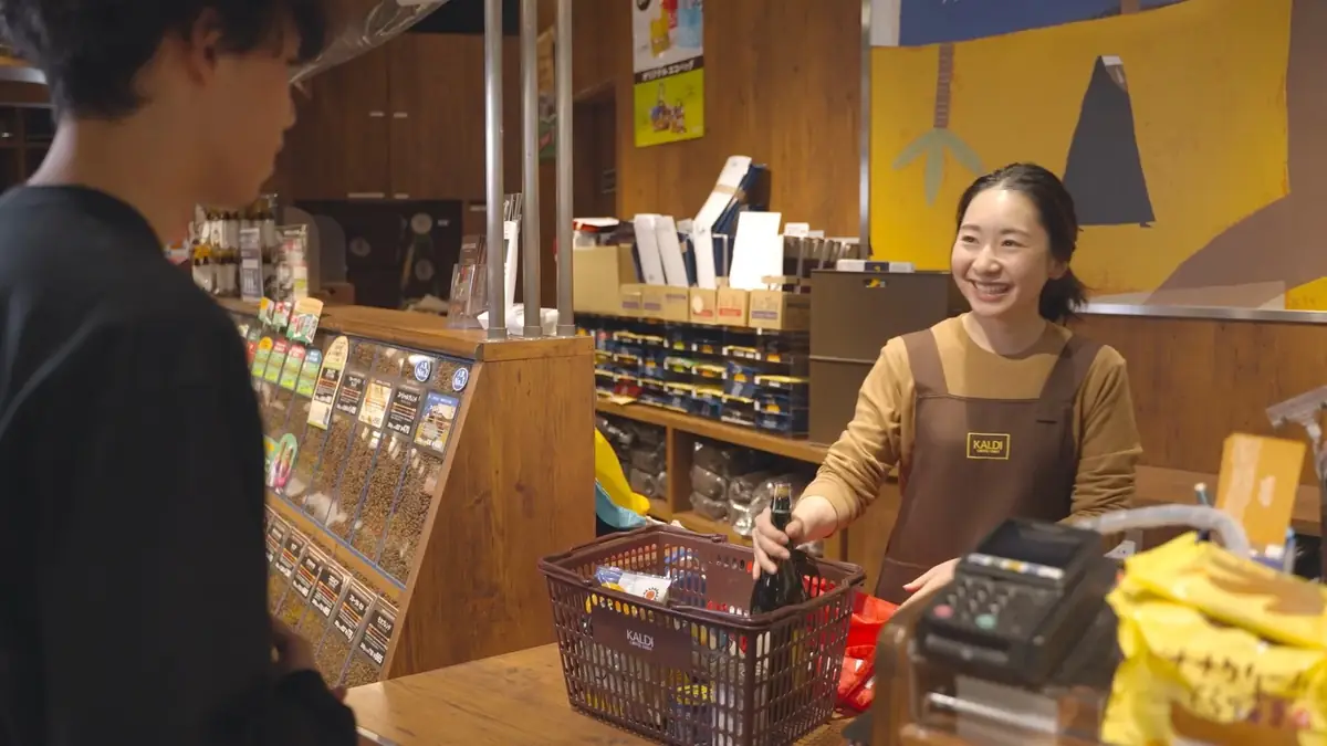 KALDI COFFEE FARM の店内で商品を並べるスタッフ