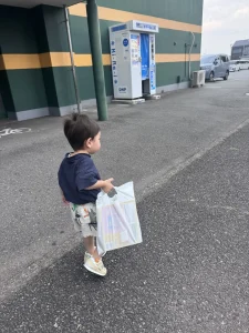 袋を持って歩く2歳8か月の息子の後ろ姿