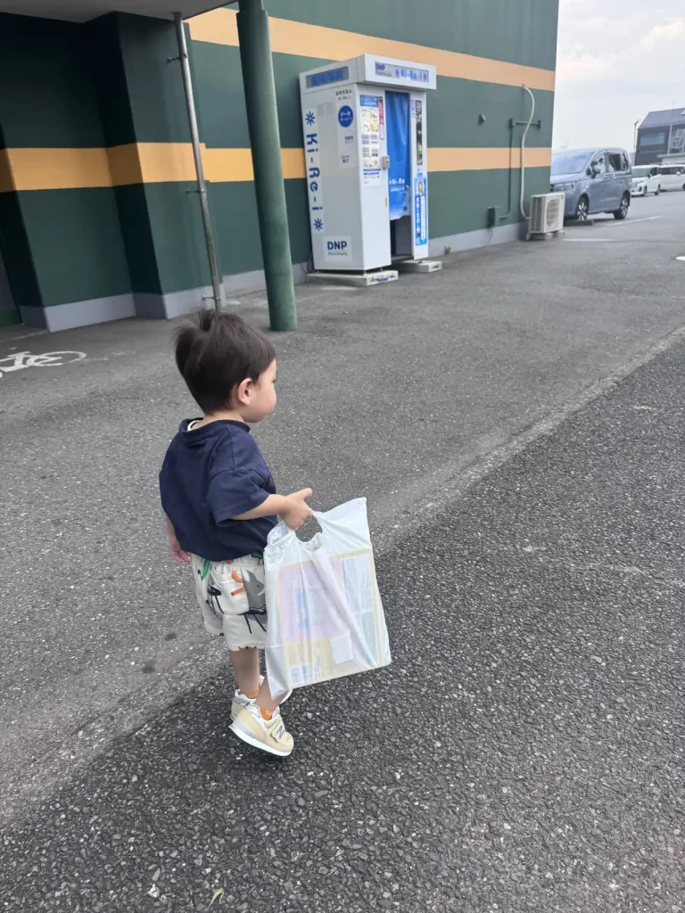 袋を持って歩く2歳8か月の息子の後ろ姿