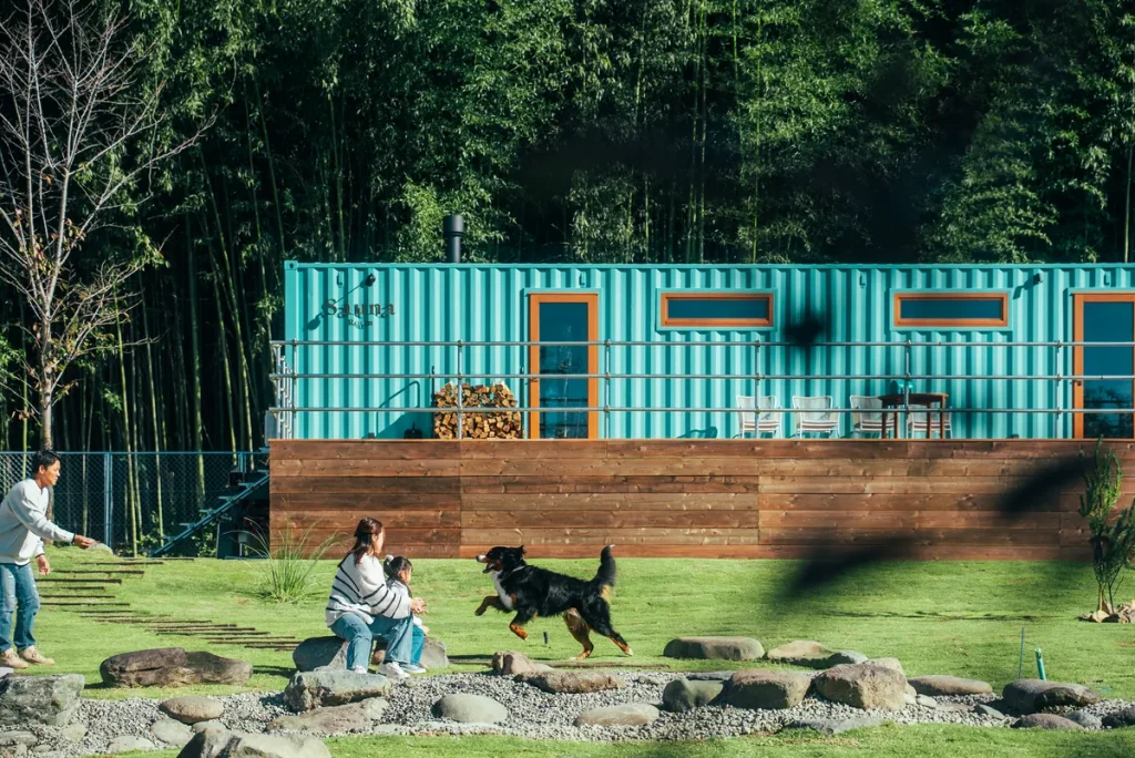 竹林とコンテナサウナの前で遊ぶ家族と犬（THE W RELAX GARDEN RESORT）