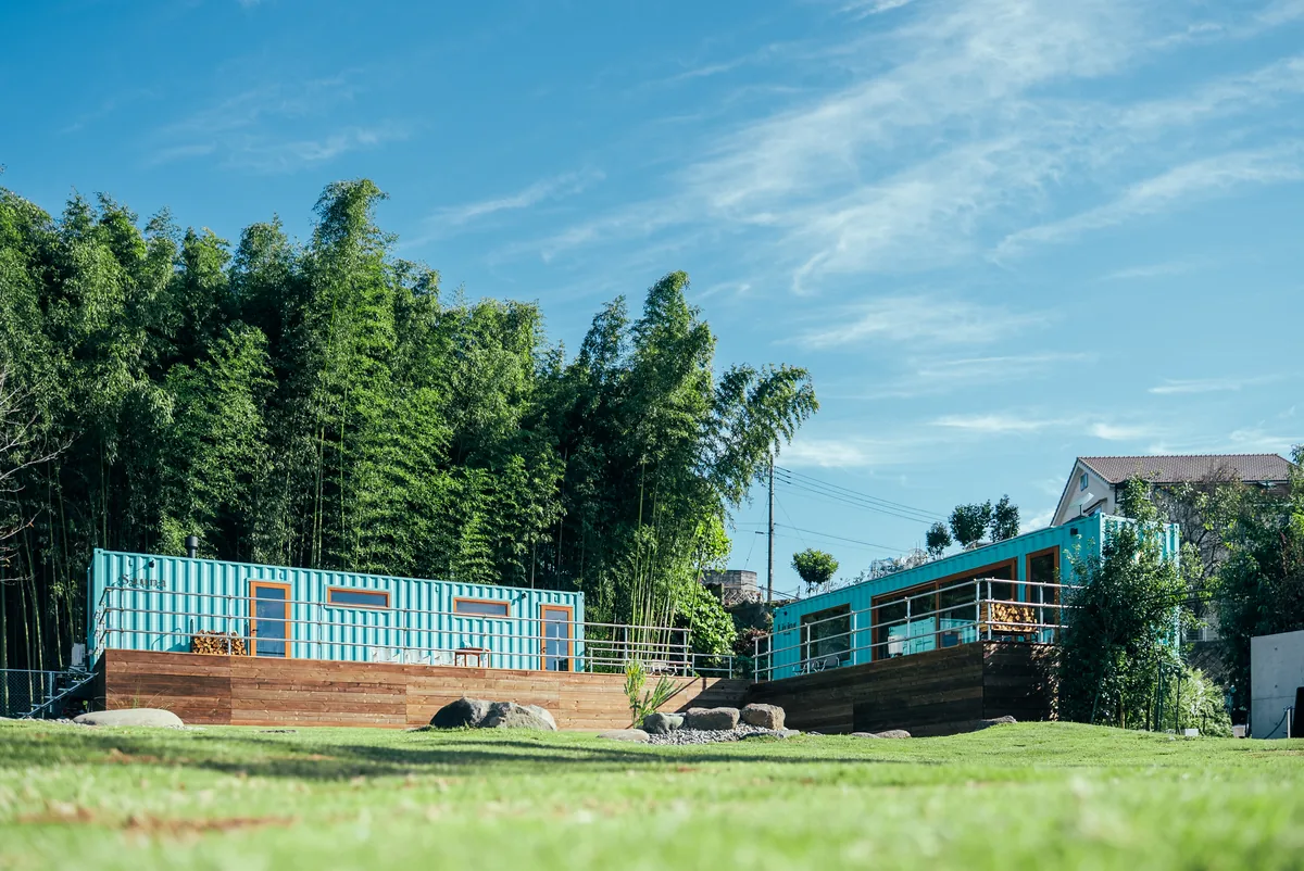 青空と竹林に囲まれたコンテナ棟の外観(THE W RELAX GARDEN RESORT)